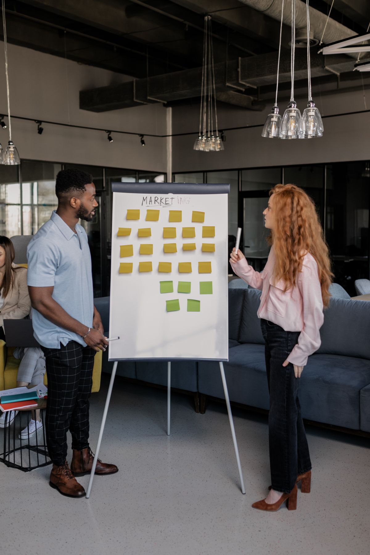 Colleagues planning a digital marketing strategy on a whiteboard with sticky notes