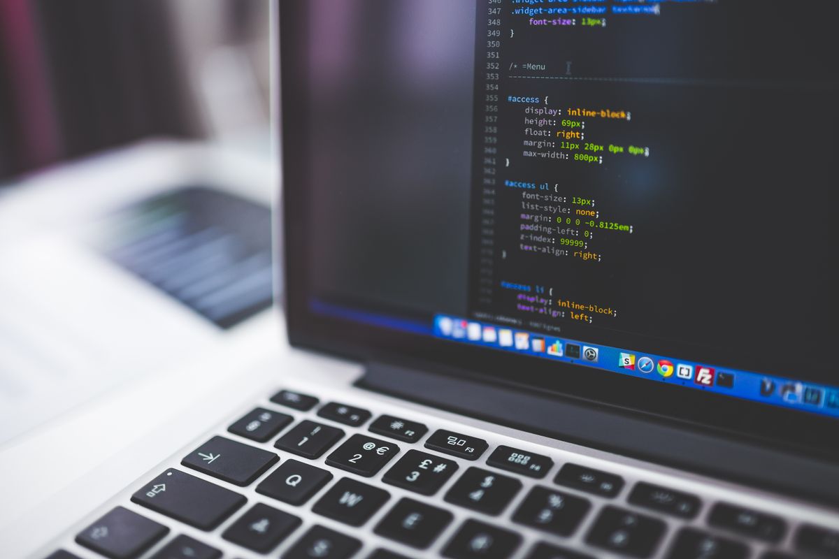 Laptop screen showing website HTML code relevant to on-page SEO structure
