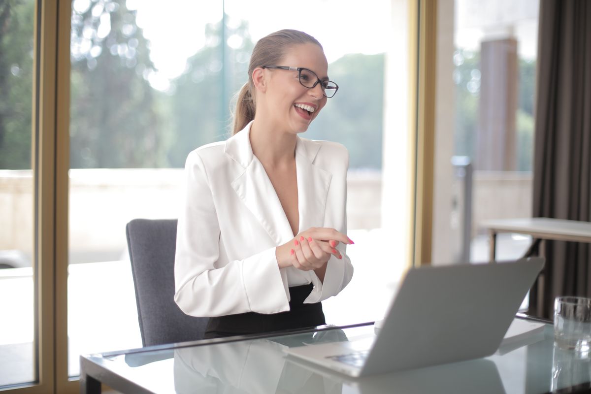 Confident business owner working on a laptop in a modern office